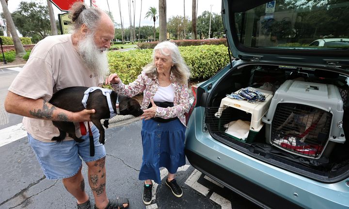 Evacuating from the likely path of Hurricane Milton, Rex and Ruby Thacher bring their dogs Lulu and Zoey to the Rosen Centre Hotel in Orlando on Monday.